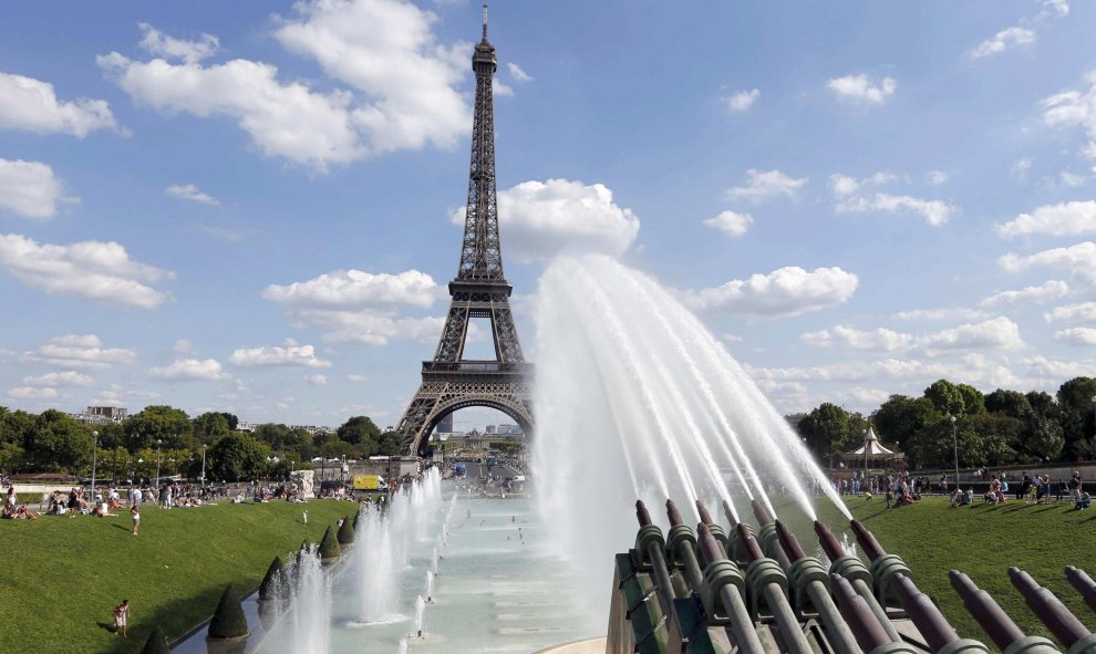 Turistas están refrescándose en las fuentes cercanas a la Torre Eiffel en París. REUTERS