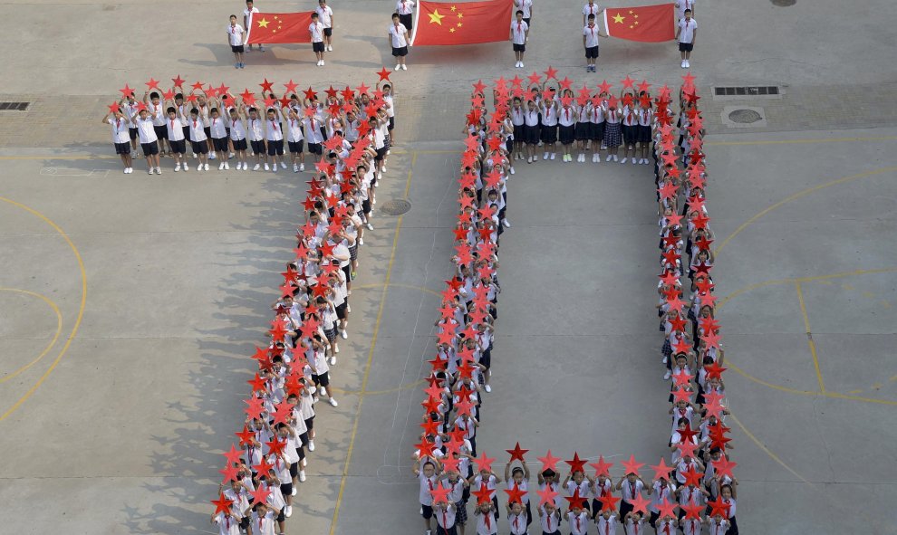 Estudiantes de un colegio de primaria forman el número "70" , con banderas nacionales chinas y estrellas rojas durante un acto de celebración del 70 aniversario de la victoria de la Guerra del Pueblo Chino de Resistencia contra la Agresión Japonesa y la G