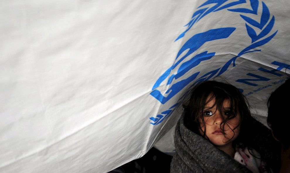 Una niña espera con otros migrantes bajo la lluvia en un campo de refugiados cerca de Gevgelija , Macedonia, después de entrar en el país por la frontera con Grecia. REUTERS