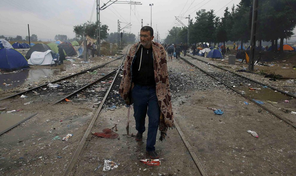 Un hombre de refugiado sirio camina cerca de la frontera entre Grecia y Macedonia. REUTERS