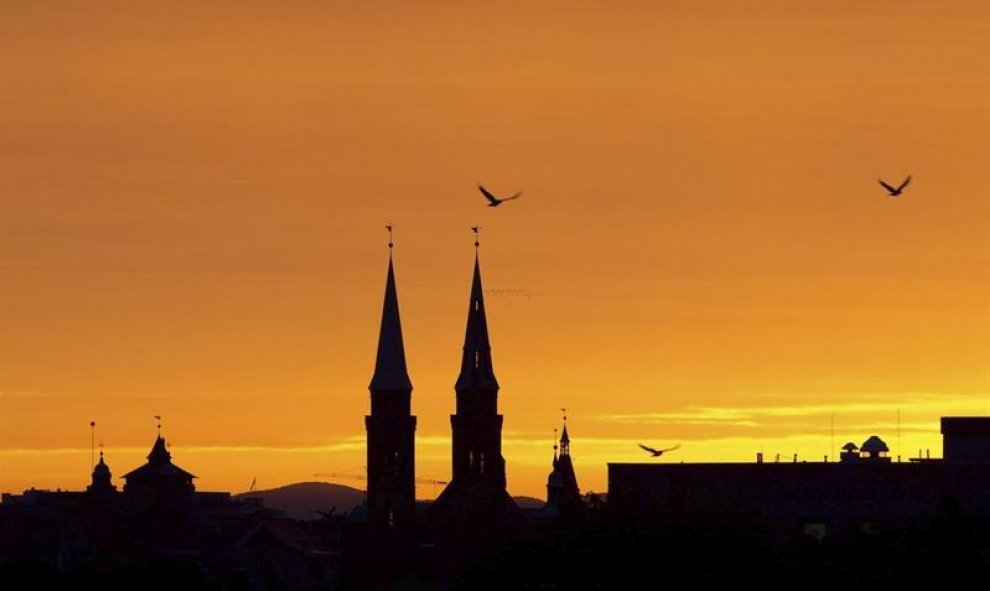 Aves sobrevuelan las Torres de St. Laurence en Nueremberg (Alemania). EFE/Daniel Karmann