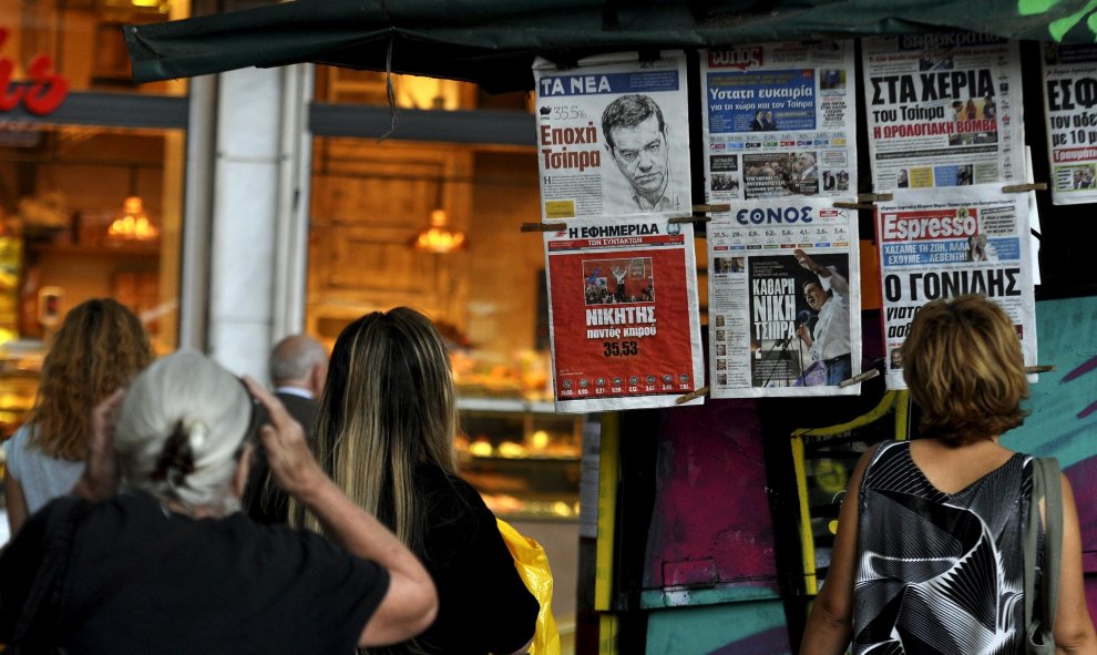 Griegos miran los titulares de la prensa en un kiosko de Atenas, con los resultados de las elecciones generales del domingo, Grecia, 21 de septiembre de 2015. REUTERS / Michalis Karagiannis
