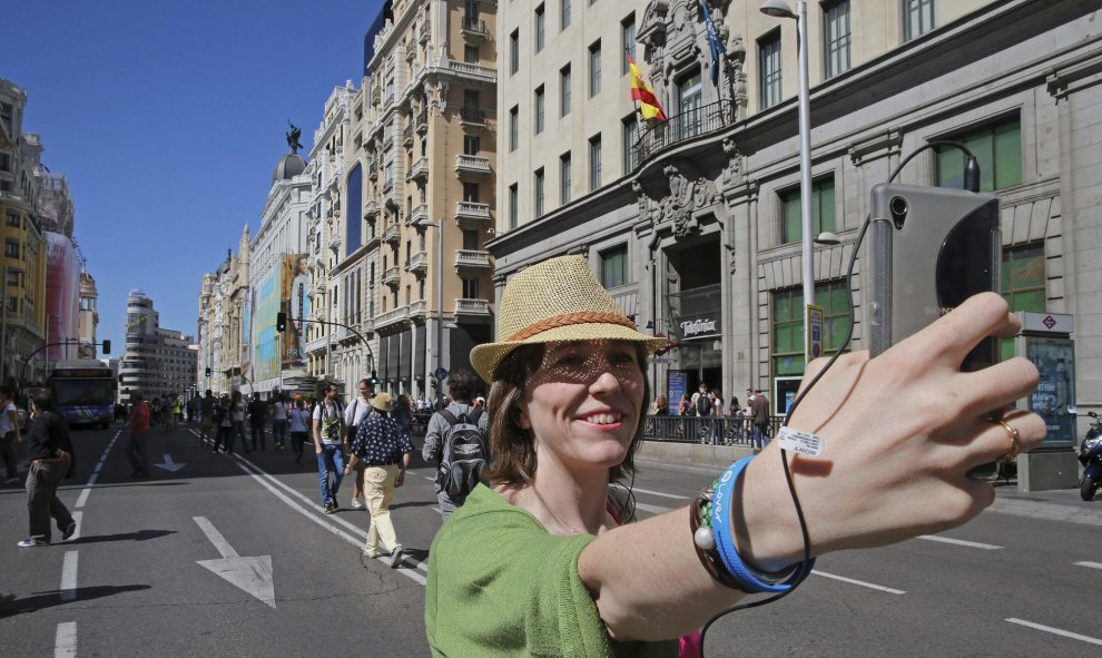 Una mujer se hace una fotografía en la Gran Vía de Madrid cerrada al tráfico con motivo del Día Sin Coches que, además de Madrid, celebran Valladolid, San Sebastián, y Valencia, entre 330 ciudades, con acciones que van desde limitar el tráfico privado en