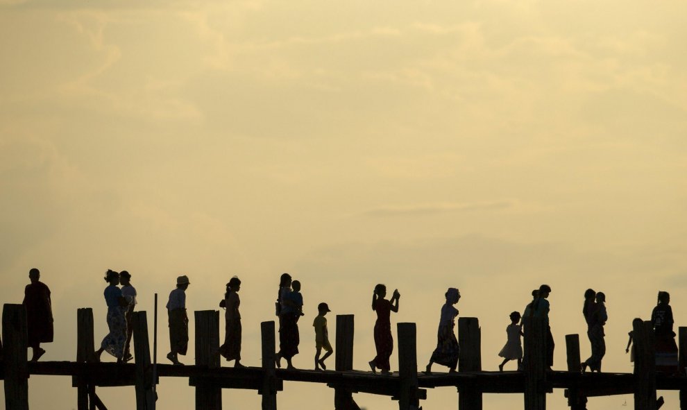 Gente cruza el puente U Bein sobre el lago Tuangthaman en Mandalay, Birmania. REUTERS / Jorge Silva