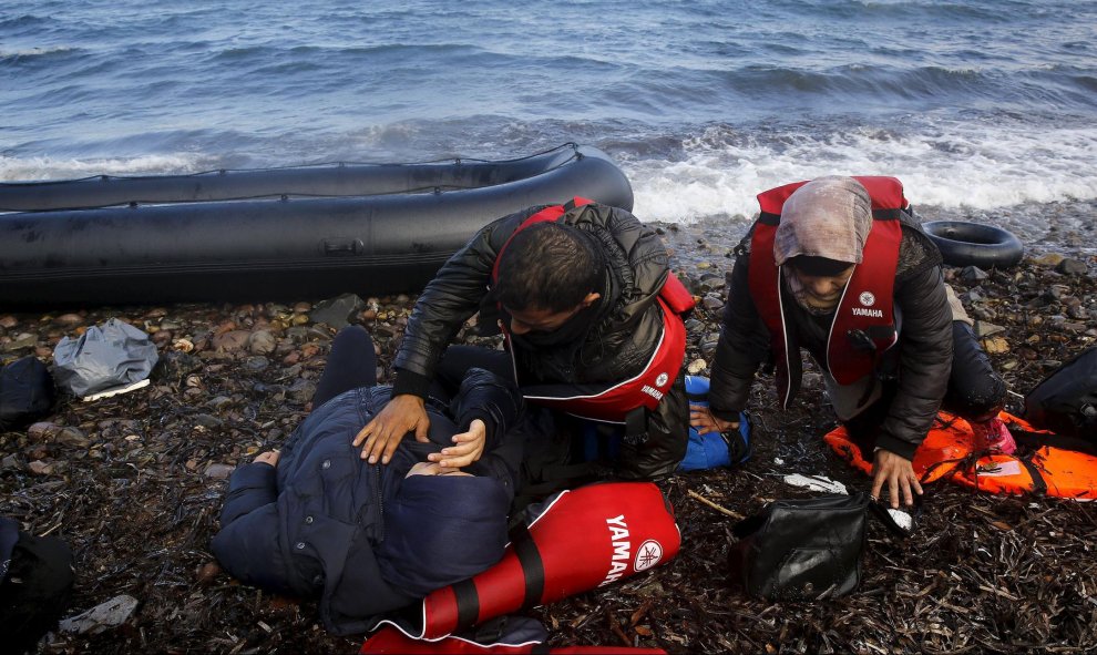 Refugiados sirios descansan agotados momentos después de desembarcar en una playa en la isla griega de Lesbos. REUTERS / Yannis Behrakis