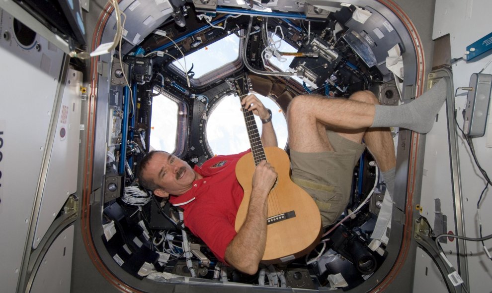 El astronauta Chris Hadfield toca la guitarra en la cúpula de la Estación Espacial Internacional, el 25 de diciembre de 2012. REUTERS / NASA