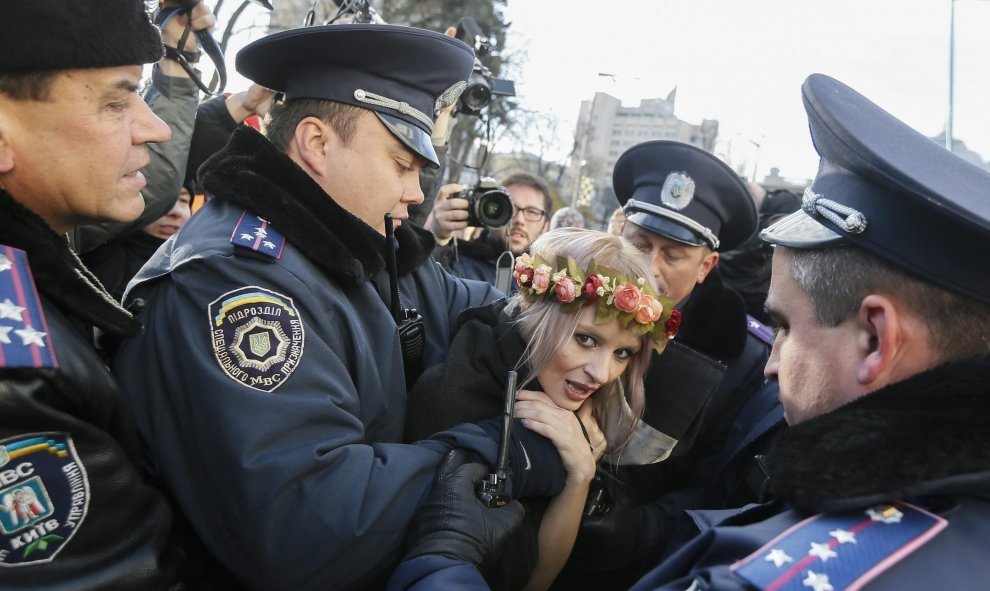 Policías ucranianos arrestan a una activista del movimiento Femen durante una protesta contra la homofobia delante del Parlamento en Kiev (Ucrania). EFE/Sergey Dolzhenko