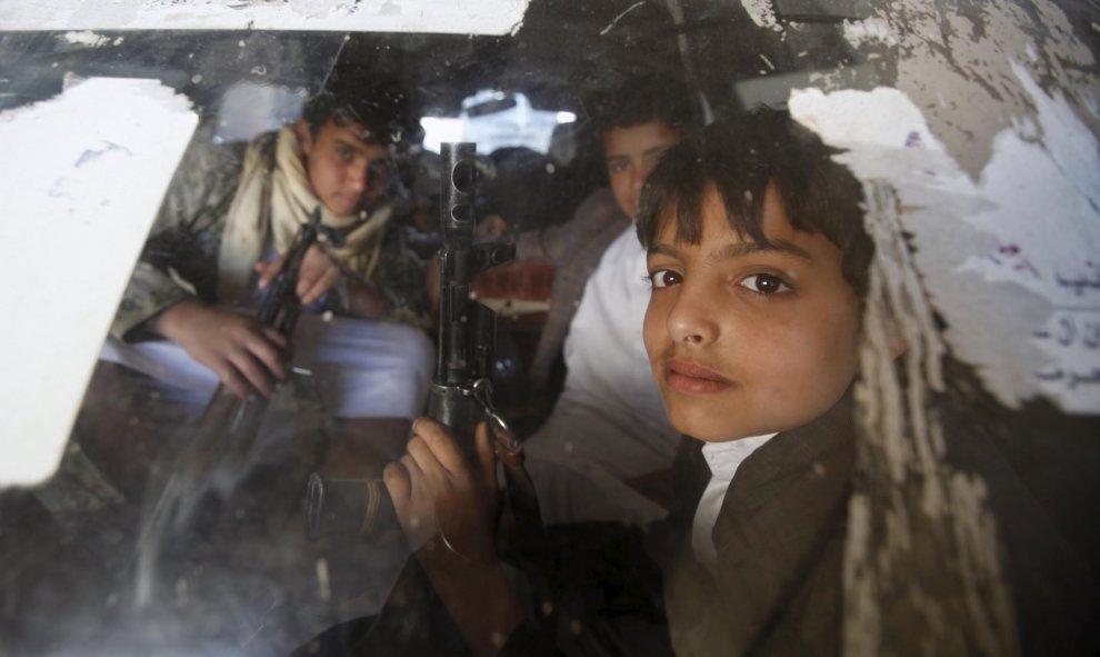 Niños con rifles mientras conducen un coche para una manifestación contra los ataques saudíes en la capital de Yemen. REUTERS/Khaled Abdullah