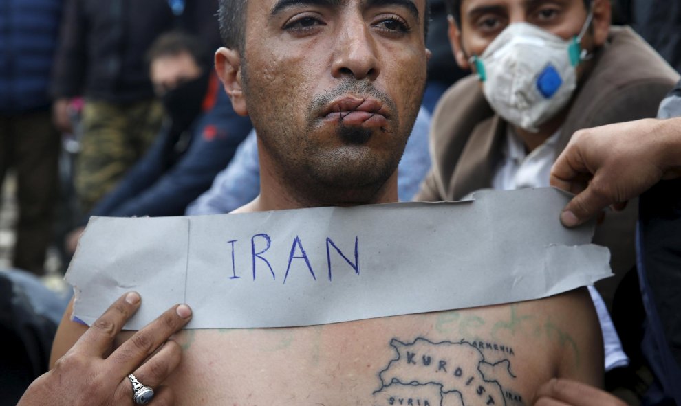 Un inmigrante iraní con los labios cosidos se sienta en las vías del tren en la frontera entre Grecia y Macedonia. REUTERS/Yannis Behrakis
