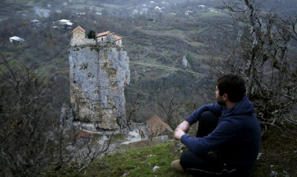 Un lugareño observa una iglesia en el punto más alto del Pilar de Katskhi de 40 metros de altura, en el pueblo de Katskhi, Georgia. REUTERS/David Mdzinarishvili