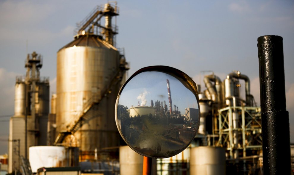 Reflejo de una fábrica de la zona industrial Keihin en una lupa. Kawasaki, sur de Tokio, Japón. REUTERS/Thomas Peter