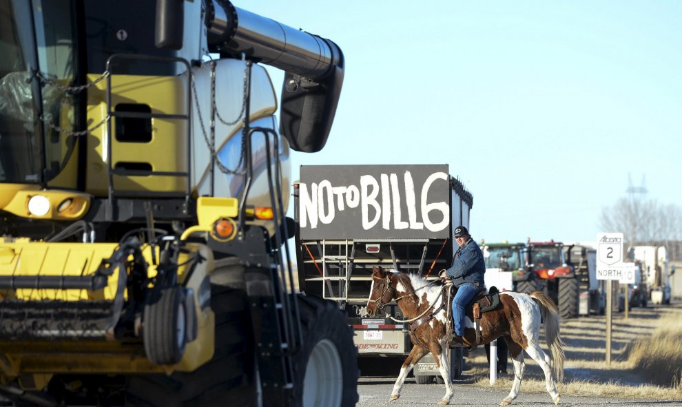 Un ranchero local monta su caballo en medio de una protesta de 50 agricultores y ganaderos que conducían tractores. Alberta, Canadá. REUTERS/Mike Sturk