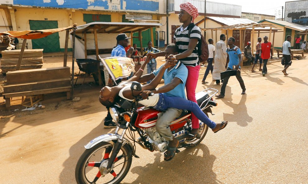 Unos africanos montan en una moto, cerca de la mezquita de Koudoukou  donde se encontraba el Papa Francisco. Bangui, República Centroafricana. REUTERS/Stefano Rellandini