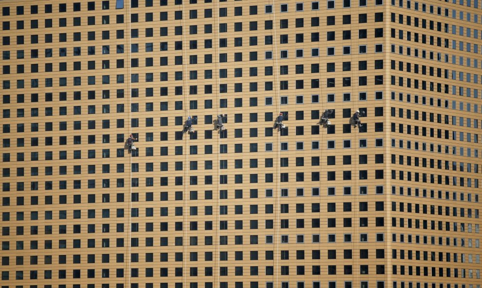 Unos trabajadores limpian un edificio en el centro de Seoul, Corea. REUTERS/Kim Hong-Ji