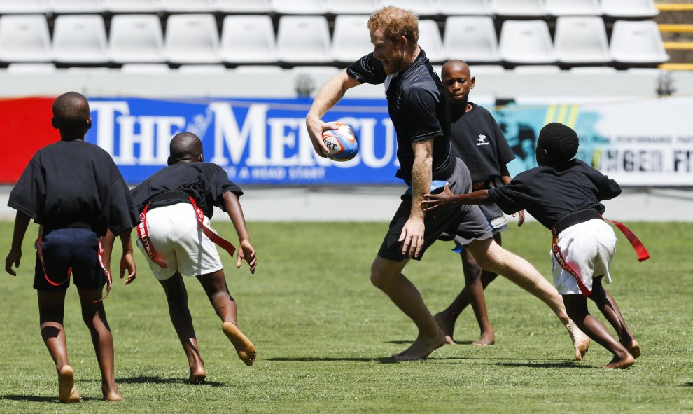 El Príncipe británico Harry juega al rugby con unos niños africanos durante el entrenamiento. Durban, Sudáfrica. REUTERS/Rogan Ward