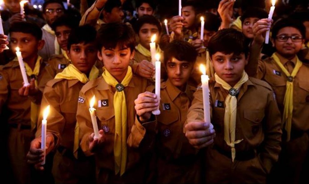 Niños sostienen antorchas durante una marcha organizada en Lahore, Pakistán, en homenaje a las víctimas del atentado talibán perpetrado en una escuela de Peshawar. Un grupo de talibanes mató a 132 estudiantes y 12 profesores tras entrar en el centro lanza
