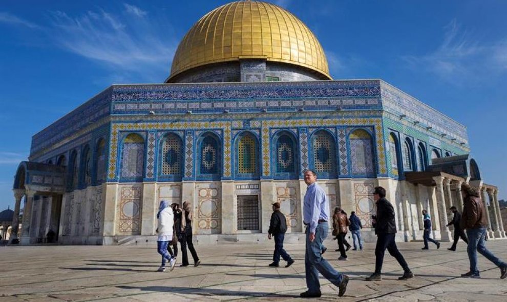 Turistas, israelíes y palestinos pasan delante de la Cúpula de la Roca, en la explanada que alberga las mezquitas, conocida como Noble Santuario para los musulmanes o como Monte del Templo para los judíos, en Jerusalén (Israel). EFE/Jim Hollander