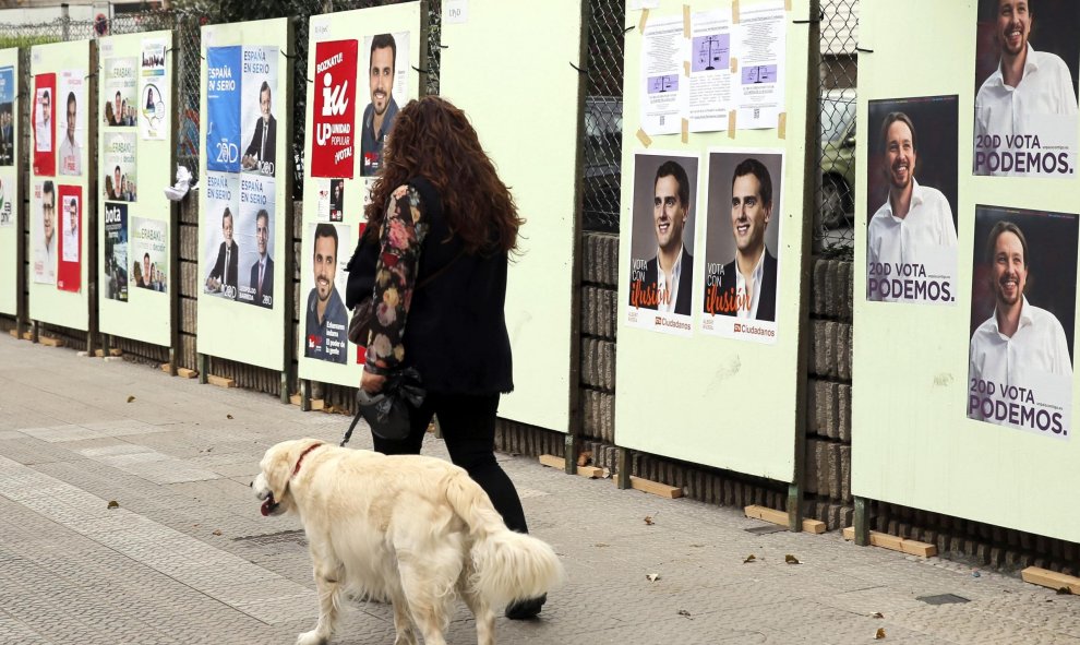 Una mujer pasa por delante de carteles electorales de los distintos candidatos a Presidente de Gobierno para las elecciones generales del próximo domingo en Santurce (Vizcaya), durante la campaña electoral para las elecciones generales del próximo 20-D. E