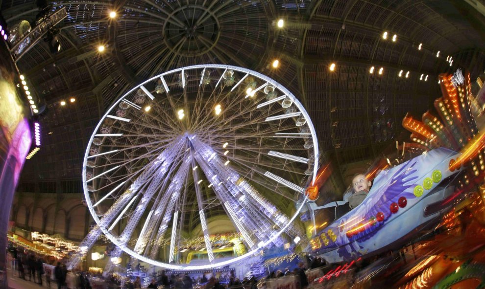 Unos niños disfrutan de las atracciones de la Feria 'Jours de Fetes', situada en Gran Palacio de París como parte de las actividades de vacaciones en París. REUTERS/Philippe Wojazer