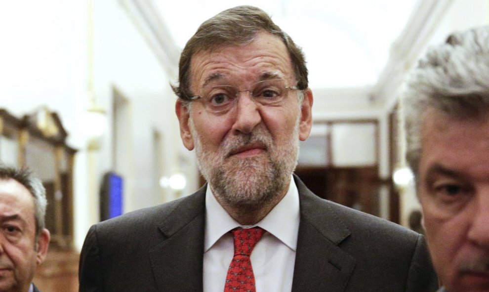 Rajoy recorre los pasillos del Parlamento de Madrid para acudir a una sesión de control del Gobierno.- REUTERS.