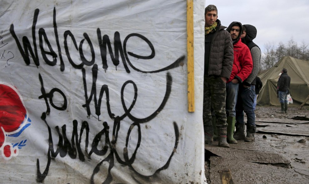 Los inmigrantes hacen cola para recibir ropa en el campamento provisional para refugiados de procedentes de Irak, Kurdistán, Irán y Siria, cerca de Dunkerque (Francia). REUTERS / Pascal Rossignol