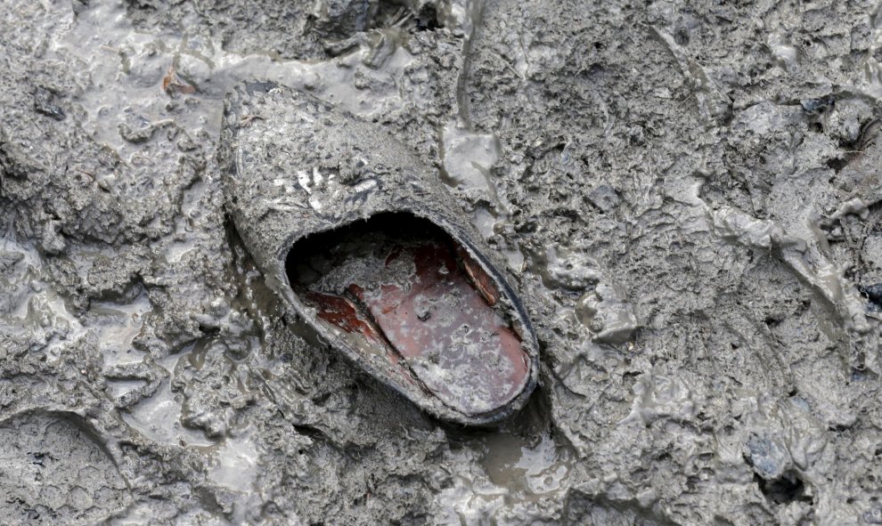 Un zapato tradicional abandonado en el suelo enfangado del campamento provisional para refugiados de procedentes de Irak, Kurdistán, Irán y Siria, cerca de Dunkerque (Francia). REUTERS / Pascal Rossignol