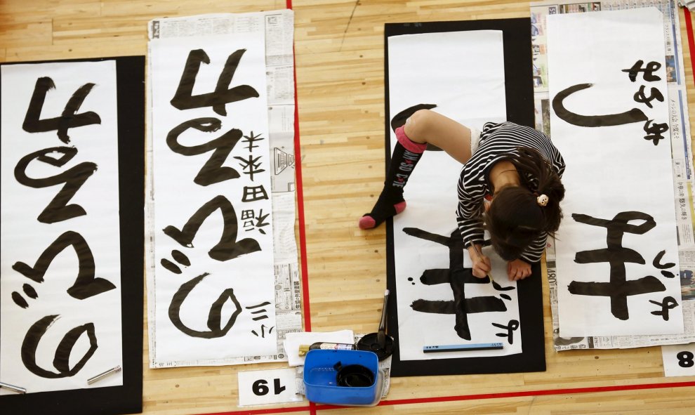 Una niña participa en un concurso de caligrafía para celebrar el Año Nuevo en Tokio. REUTERS/Thomas Peter