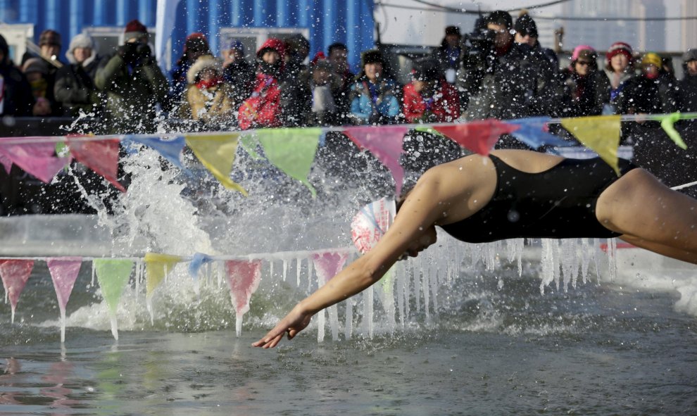 Un nadador se sumerge en una piscina en el hielo que cubre el río Songhua durante una competición de natación en la ciudad de Harbin, en China. REUTERS/Aly Song