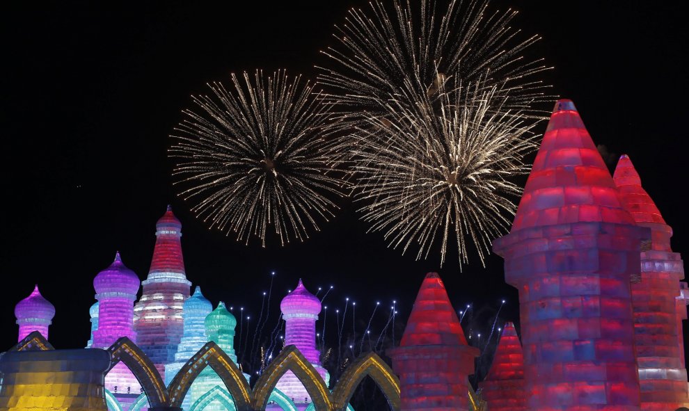 Fuegos artificiales iluminan el cielo tras las esculturas de hielo en la jornada inaugural del Festival Internacional de hielo y nieve de Harbin, en la provincia de Heilongjiang, en China. REUTERS/Aly Song