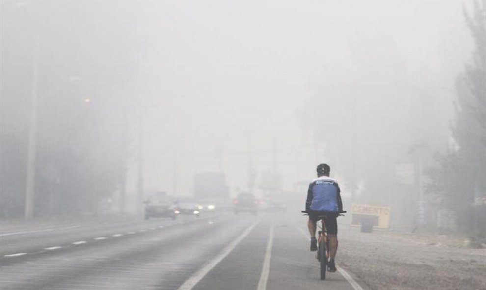 Fotografía de un ciclista entre la contaminación de la ciudad de Santiago (Chile). EFE/Elvis González