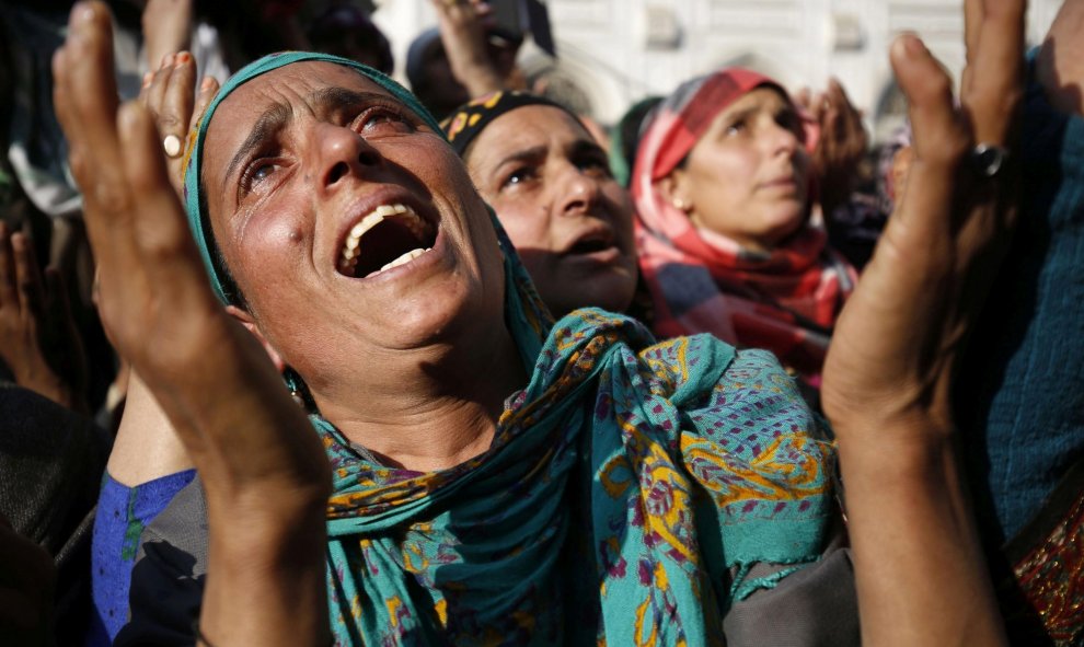 Mujeres cachemiras rezan mientras un clérigo enseña la reliquia del jeque Syed Abdul Qadir Jeelani en su templo en Srinagar, la capital estival de la parte de Cachemira administrada por la India. EFE/Farooq Khan