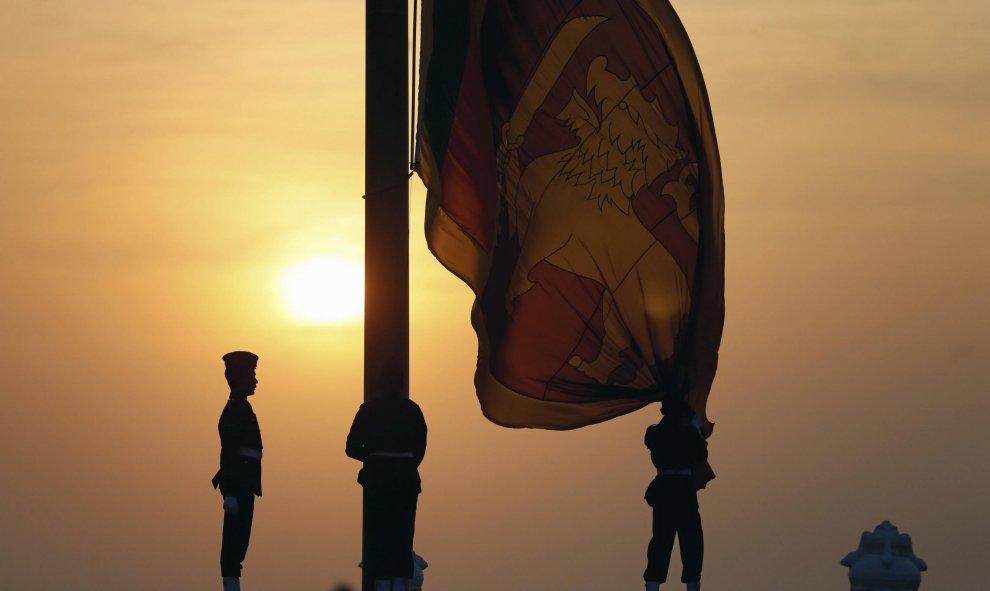 Un oficial de la fuerza aérea iza la bandera nacional de Sri Lanka al ponerse el sol en Galle Face Green en Colombo, Sri Lanka, 3 de febrero de 2016. Los habitantes celebrarán el 68º aniversario de día de la Independencia el 4 de febrero. REUTERS / Dinuka