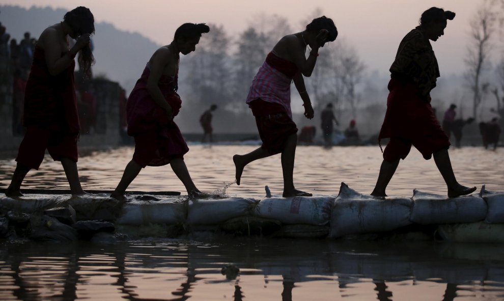 Devotos regresan después de tomar un baño sagrado en el río durante el festival Triveny Swasthani Brata Katha en Panauti, Nepal. REUTERS/Navesh Chitrakar