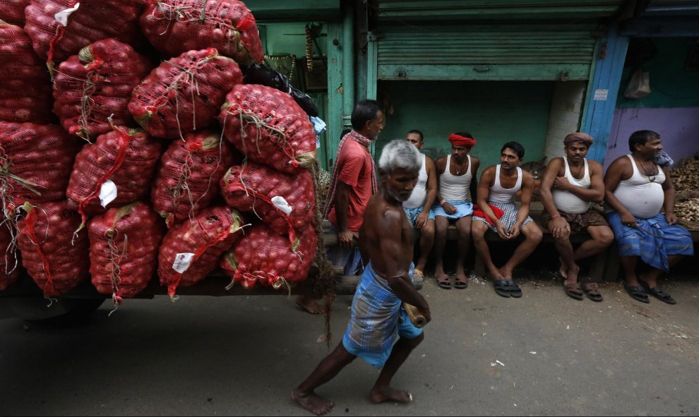 Trabajadores tiran de una carretilla cargada con sacos en un mercado al por mayor en Calcuta, India. REUTERS/Rupak De Chowdhuri