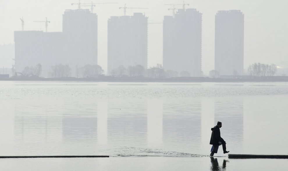 Un hombre camina por un lago artificial en Taiyuan, provincia de Shanxi, China. REUTERS/Jon Woo