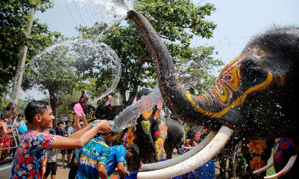 Un niño y un elefante se salpican el uno al otro con agua durante la celebración del festival de Songkran en la provincia de Ayutthaya de Tailandia. REUTERS/Jorge Silva