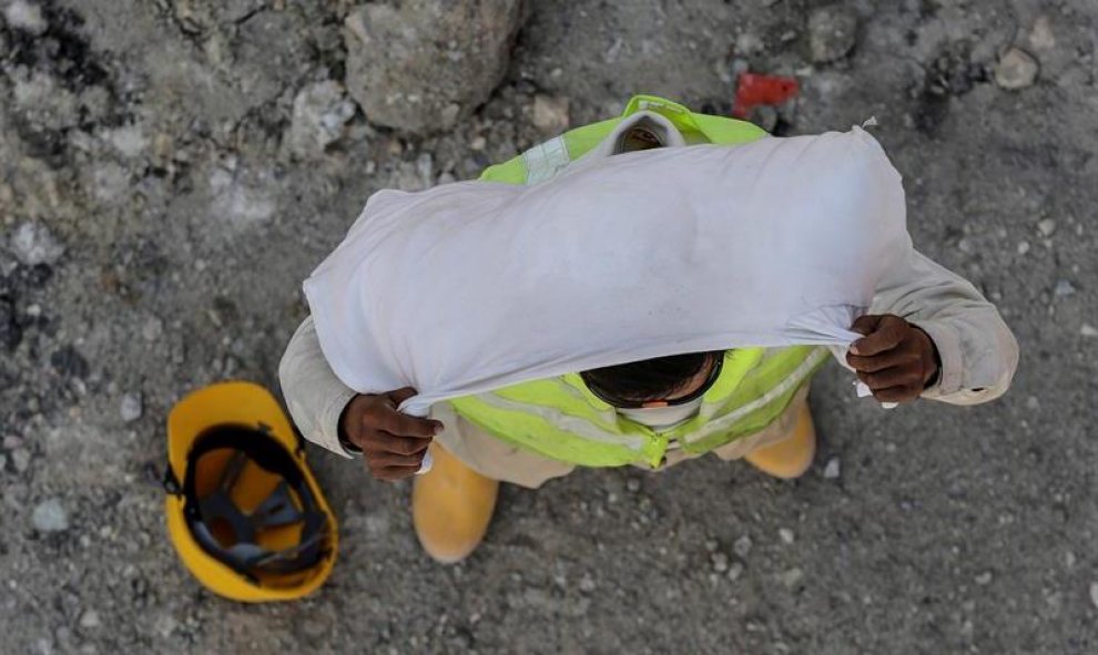 Un trabajador de la construcción usa una toalla pequeña para taparse la cabeza antes de comenzar su jornada laboral, en Kuala Lumpur, Malasia. EFE/Fazry Ismail