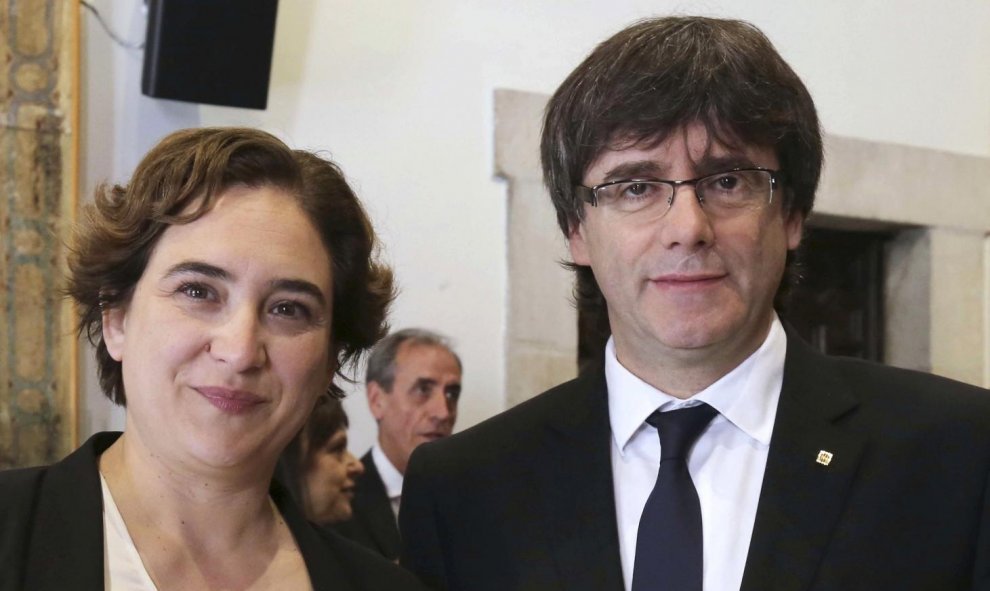 Carles Puigdemont, junto a la alcaldesa de Barcelona, Ada Colau, tras regalarle la tradicional rosa, con motivo de la festividad de Sant Jordi. EFE/Ruben Moreno