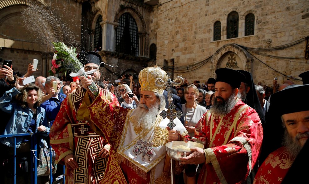 El patriarca griego ortodoxo Theophilos bendice a la multitud durante la ceremonia del 'Lavapiés' fuera de la Iglesia del Sagrado Sepulcro en la ciudad vieja de Jerusalén. REUTERS/Ammar Awad