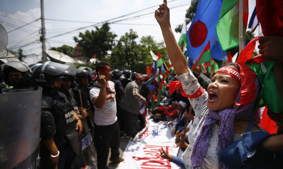na simpatizantes de las minorías étnicas grita consignas antigobierno frente a los agentes antidisturbios durante una marcha hacia la sede del Gobierno durante para protestar a favor de una nueva división administrativa en Nepal, en Katmandú. EFE/Narendra