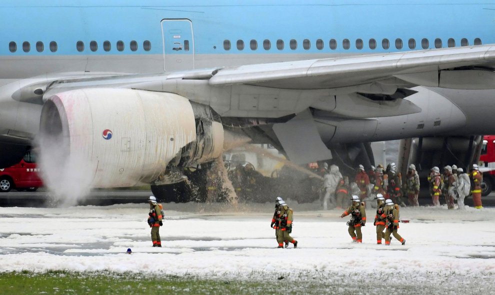 Bomberos rocían espuma en el motor de un avión de Korean Air Lines  incendiado en el aeropuerto de Haneda en Tokio , Japón.- Kyodo / vía REUTERS