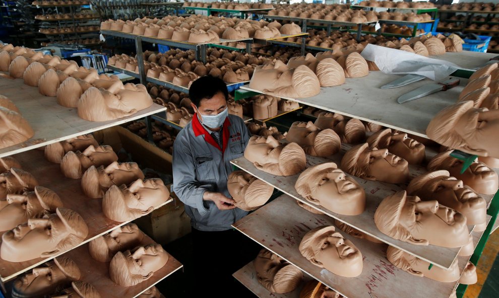 Trabajador de una factoría en China verifica una remesa de máscaras del rostro del que se postula como líder republicano de cara a las elecciones presidenciales de EEUU.- REUTERS