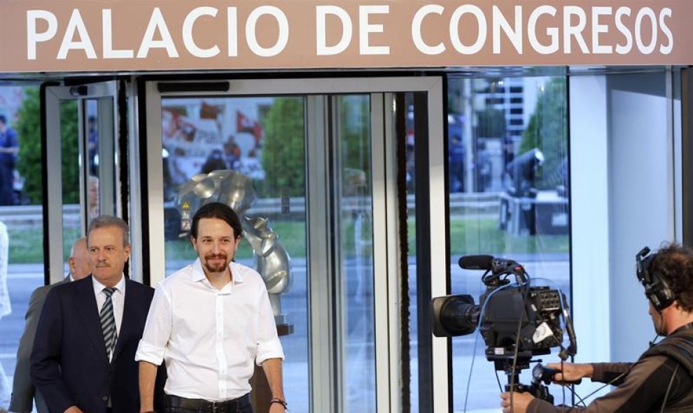 El candidato por Unidos Podemos a la presidencia del Gobierno, Pablo Iglesias (d), acompañado por el presidente de la Academia de la Televisión, Manuel Campo Vidal (i), a su llegada al Palacio Municipal de Congresos de Madrid, donde se celebra el único d