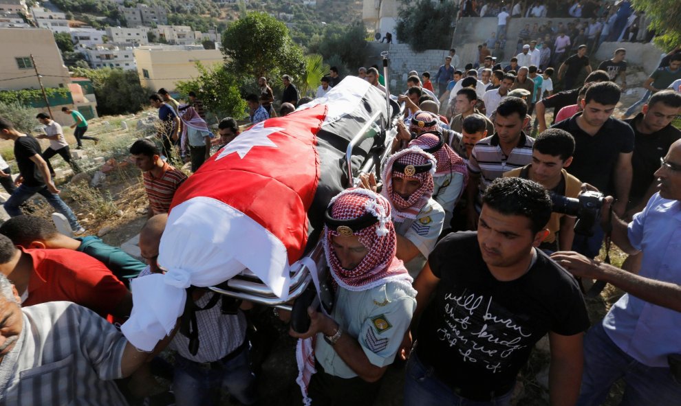 Doldados jordanos y familiares de Belal Al- Zuhbe , uno de los soldados muertos en un ataque contra un puesto militar fronterizo cerca de un campamento de refugiados sirios , llevan su cuerpo durante su funeral en el pueblo de Nahleh.- REUTERS