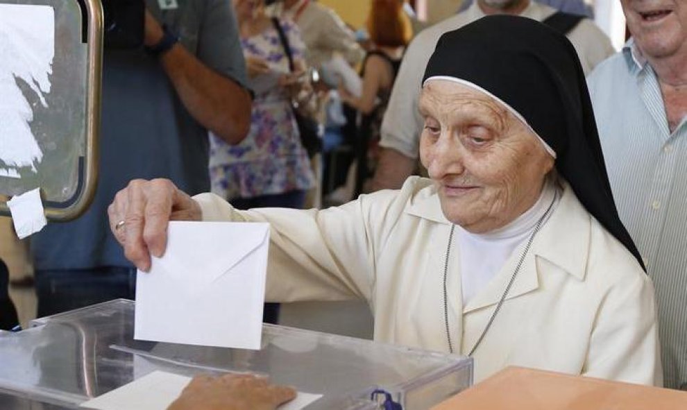 Una monja deposita su voto en un colegio del barrio de Aravaca, en Madrid