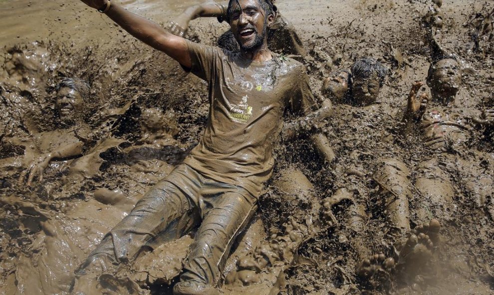 Estudiantes nepalíes del colegio agrícola del Himalaya se zambullen en un charo de barro para celebrar el Día Nacional del Arroz en la población de Badegaun, en Nepal. EFE/Narendra Shrestha