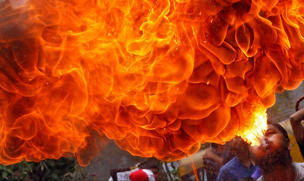 Un devoto hindú realiza un truco con fuego durante un ensayo para la Rath Yatra anual en Ahmedabad, India. REUTERS/Amit Dave