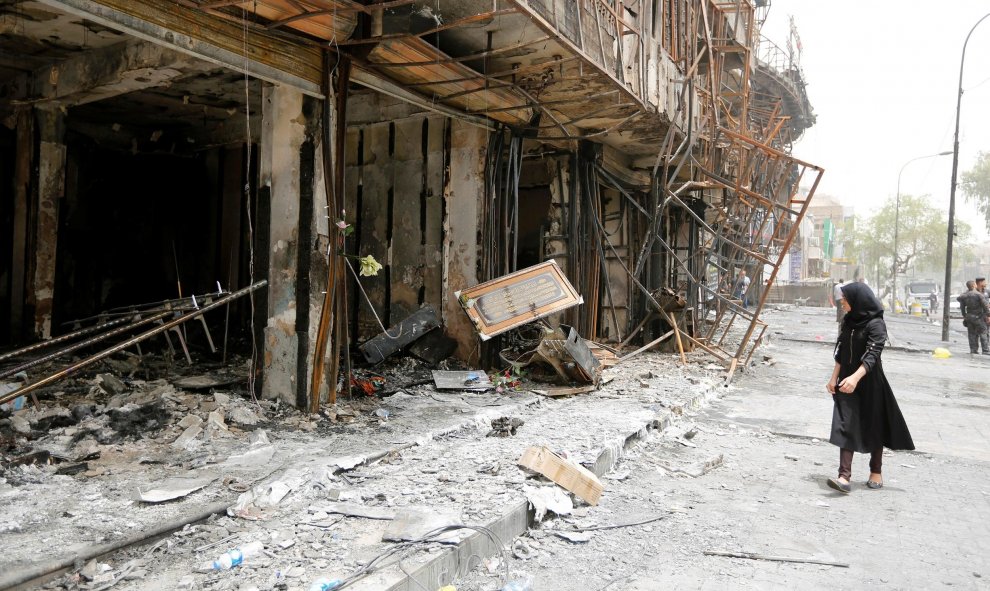 Una niña camina frente a un edificio dañado tras un ataque suicida con coche bomba en la zona comercial de Karrada , un distrito mayormente chiíta , en Bagdad , Iraq.- REUTERS / Ahmed Saad