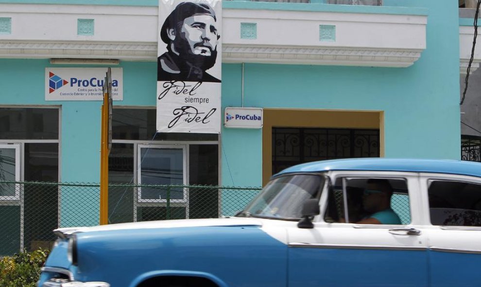 Un vehículo pasa junto a un cartel del líder de la revolución cubana Fidel Castro, en La Habana (Cuba). EFE/Ernesto Mastrascusa