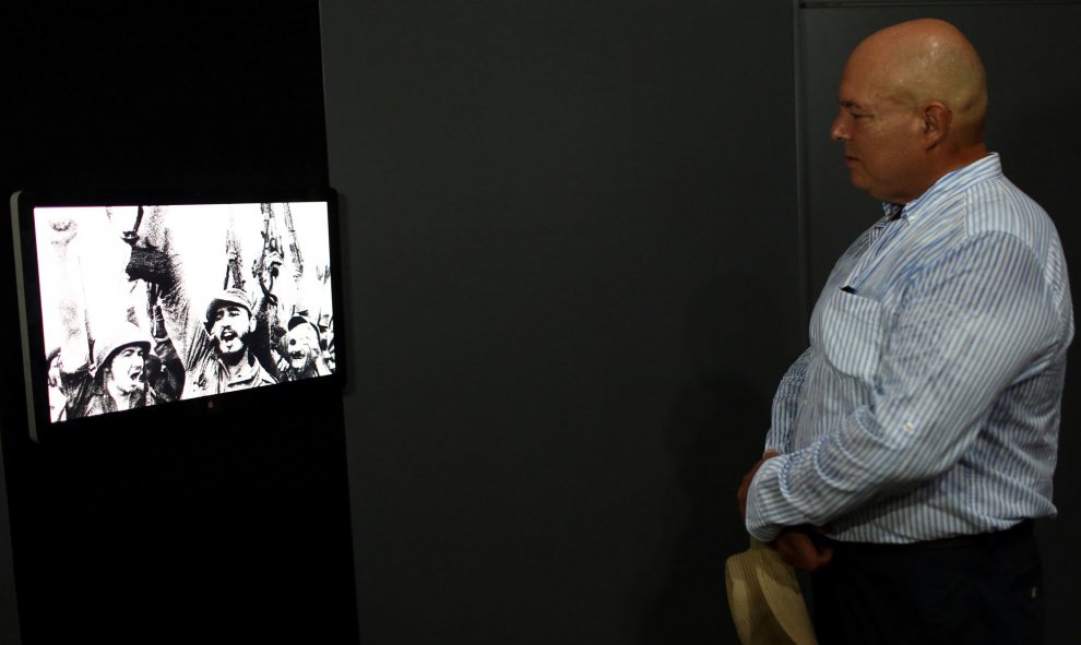 Alex Castro, fotógrafo e hijo de Fidel Castro, observa una foto del líder de la revolución cubana con su hermano, el actual presidente Raúl Castro, en la exposición 'Fidel', con motivo de su 90 cumpleaños. REUTERS/Alexandre Meneghini